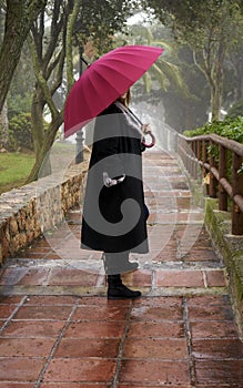 Portrait of beautiful blonde woman with red umbrella