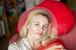 Portrait of Beautiful blonde woman sitting by the window