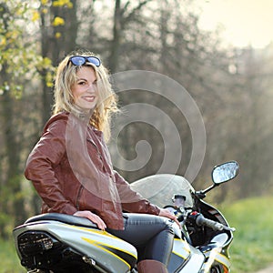 Portrait of a beautiful blonde woman on a sports motorcycle