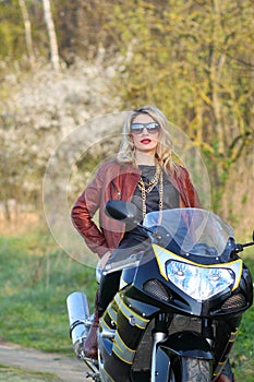 Portrait of a beautiful blonde woman on a sports motorcycle