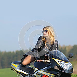 Portrait of a beautiful blonde woman on a sports motorcycle