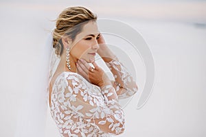 Portrait of a beautiful bride in the desert, blonde posing for a photographer on a wedding day