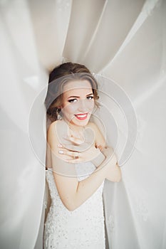 Portrait of beautiful bride with fashion veil and dress at wedding morning