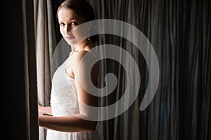 Portrait of beautiful bride standing by window at home