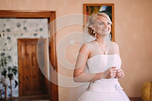 Portrait of beautiful bride waiting for a groom at home at weddi