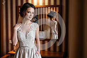 Portrait of a beautiful bride in a wedding dress standing in a room