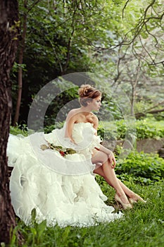 Portrait of a beautiful bride woman sits in a profile and looks into the distance.