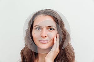 Portrait of beautiful brown hair young woman, touching her face. Scin care, natural beauty, perfect skin,cosmetics and wellness