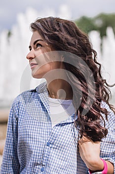 Portrait of a beautiful brunet girl touching her thick wavy hai