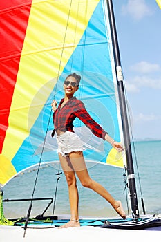Portrait of beautiful brunette girl holds boat sails and smiling