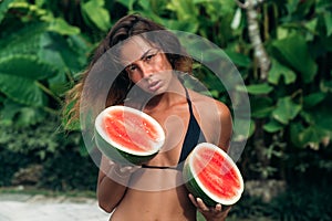Portrait beautiful brunette girl in swimsuit with watermelon fruit holding in hands. model with perfect body, cute