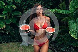 Portrait beautiful brunette girl in swimsuit with watermelon fruit holding in hands. model with perfect body, cute