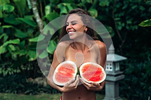 Portrait beautiful brunette girl in swimsuit with watermelon fruit holding in hands. model with perfect body, cute