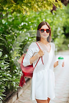 Portrait of beautiful brunette girl walking down the street.