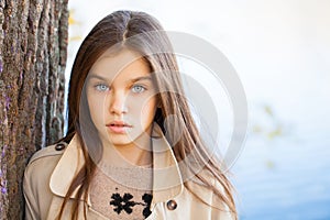 Portrait of a beautiful brunette little girl, autumn park outdoors