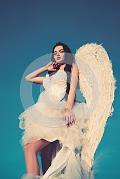 Portrait of beautiful brunette woman with angel& x27;s wings. Angel with long curly hair.