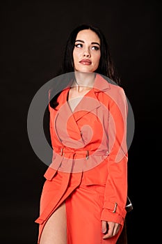 Portrait of a beautiful brunette woman in an orange dress