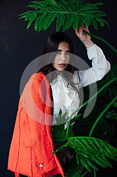 Portrait of a beautiful brunette woman of oriental appearance and green plant