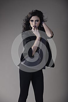 Portrait of beautiful brunette woman wearing edgy dark outfit