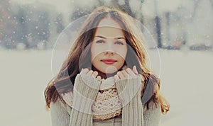 Portrait beautiful brunette young woman wearing a scarf in winter over a snowflakes background