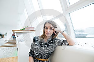 Portrait of a beautiful business woman in a modern and stylish cafe near the window.