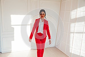 Portrait of a beautiful business woman in a red business suit in the office