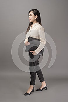 Portrait of beautiful business woman smiling on gray background