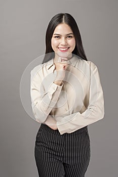 Portrait of beautiful business woman smiling on gray background