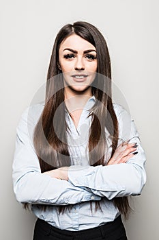 Portrait of a beautiful business woman standing with hands folded and looking at camera