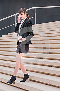 Portrait of beautiful business woman using smartphone on her way to work