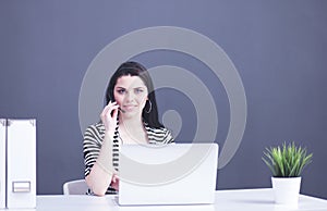 Portrait of beautiful business woman working at her desk with headset and laptop