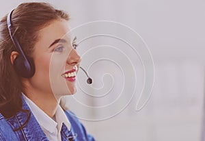 Portrait of beautiful business woman working at her desk with headset and laptop