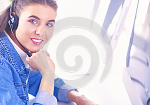 Portrait of beautiful business woman working at her desk with headset and laptop