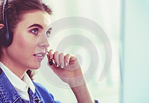 Portrait of beautiful business woman working at her desk with headset and laptop