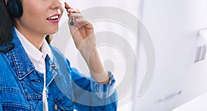 Portrait of beautiful business woman working at her desk with headset and laptop