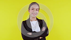 Portrait beautiful businesswoman in suit with arms crossed standing isolated on yellow background.