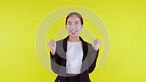 Portrait beautiful businesswoman in suit standing with glad and success isolated on yellow background.