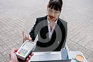 Portrait of beautiful businesswoman using using credit card for payment in coffee shop outdoors