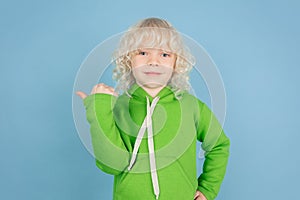 Portrait of beautiful caucasian little boy isolated on blue studio background