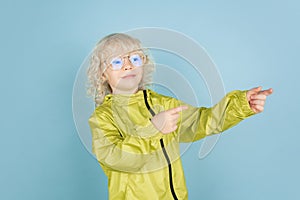 Portrait of beautiful caucasian little boy isolated on blue studio background