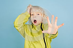 Portrait of beautiful caucasian little boy isolated on blue studio background