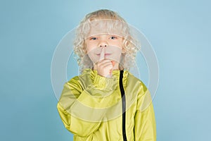 Portrait of beautiful caucasian little boy isolated on blue studio background