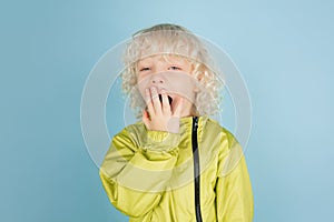 Portrait of beautiful caucasian little boy isolated on blue studio background