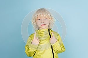 Portrait of beautiful caucasian little boy isolated on blue studio background