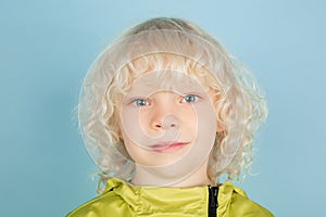 Portrait of beautiful caucasian little boy isolated on blue studio background