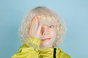 Portrait of beautiful caucasian little boy isolated on blue studio background