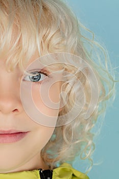 Portrait of beautiful caucasian little boy isolated on blue studio background