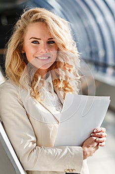 Portrait of beautiful caucasian smiling woman with papers. Business concept