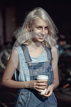 Portrait of beautiful Caucasian teenage young blonde alternative model girl woman in blue tshirt, jeans romper looking in camera