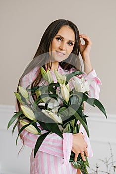 Portrait of a beautiful caucasian woman in her thirties with a bouquet of white lilies